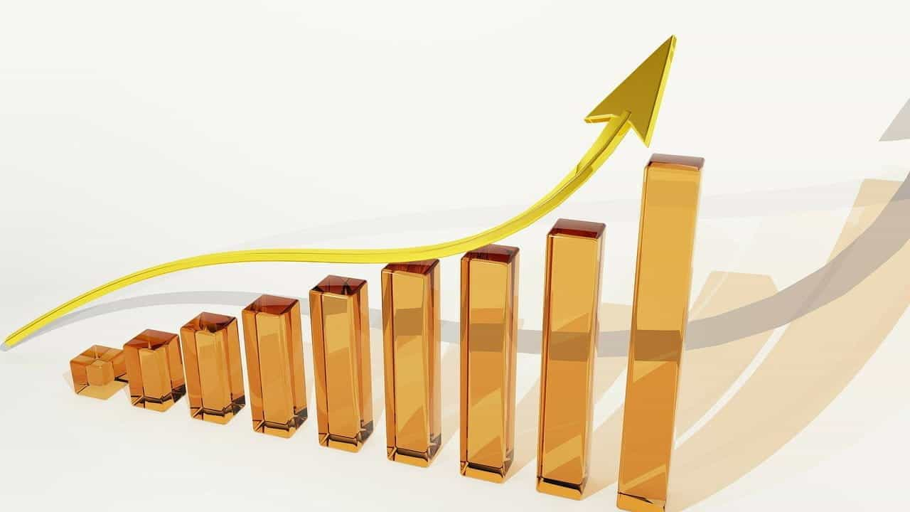 A digital graphic of a bar graph of bars steadily rising in size. A large yellow arrow swoops over the graph to demonstrate its upward incline.