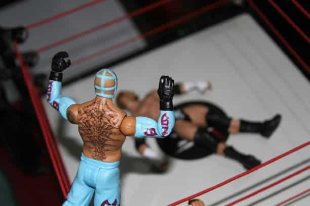 Figurines of two WWE fighters face off in the ring.