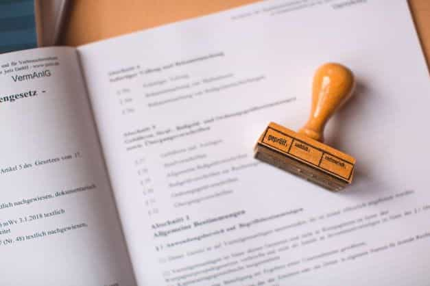 A brown rubber stamp placed atop some documents.