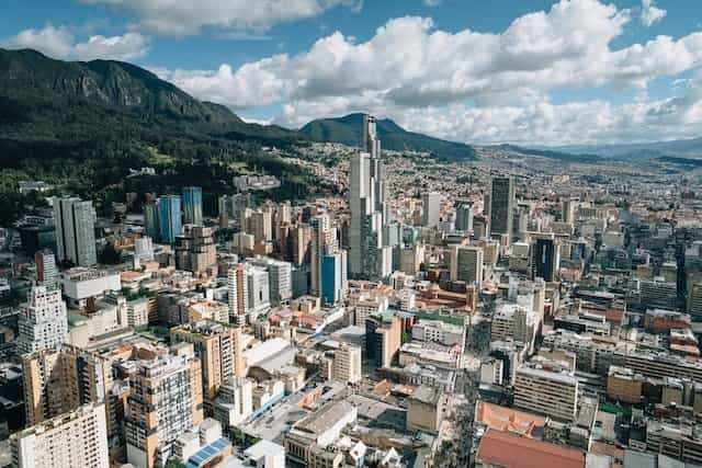 High rise buildings in the city of Bogotá, Colombia, with mountains in the background.