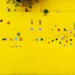 A highly decorated bright yellow wall and blue-green door in Salta, Argentina.